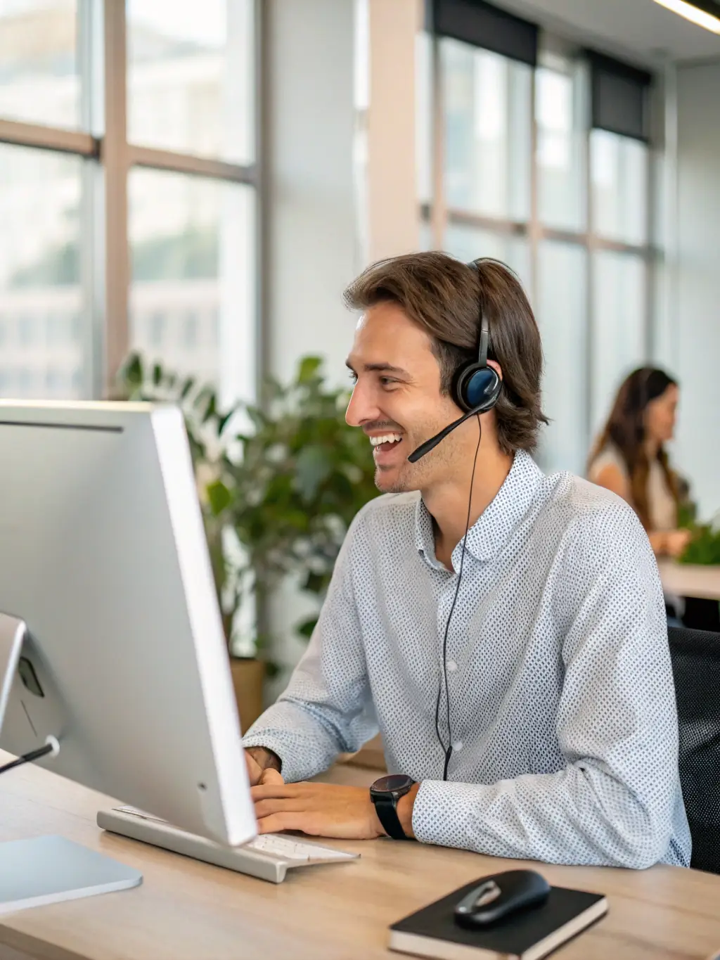A friendly technical support agent assisting a customer over a video call, with a headset on and a helpful expression, in a modern office environment. The image should convey approachability and real support.